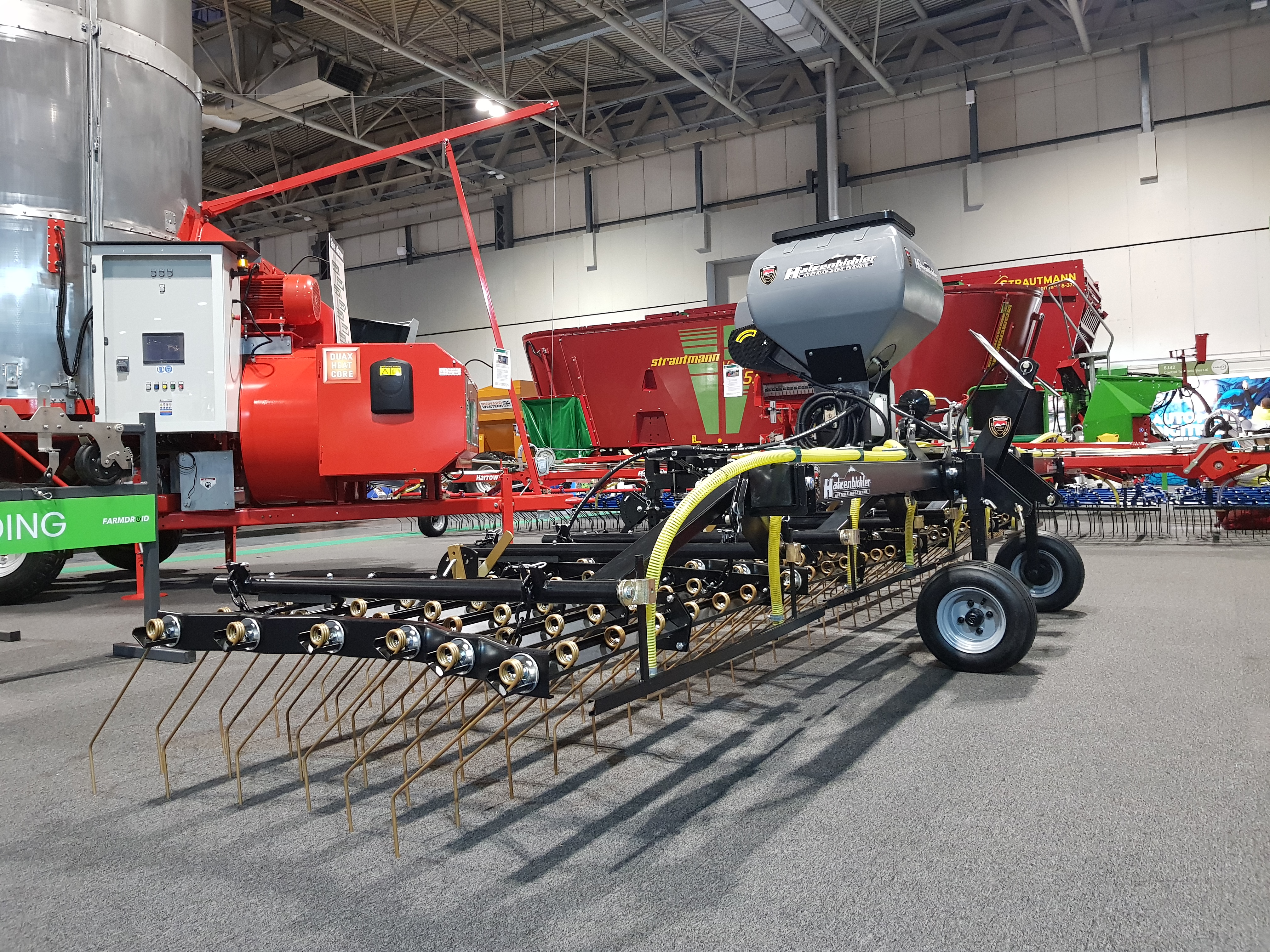 Black and gold 6m OPICO Grass Harrows and seeder on the stand at LAMMA 2025